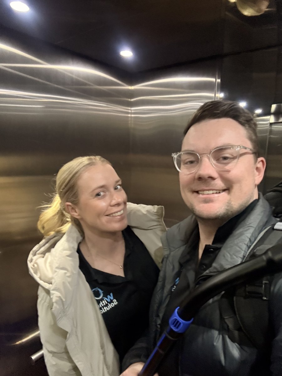 Ryan and Emma taking a selfie in the lift on the way up to an office clean